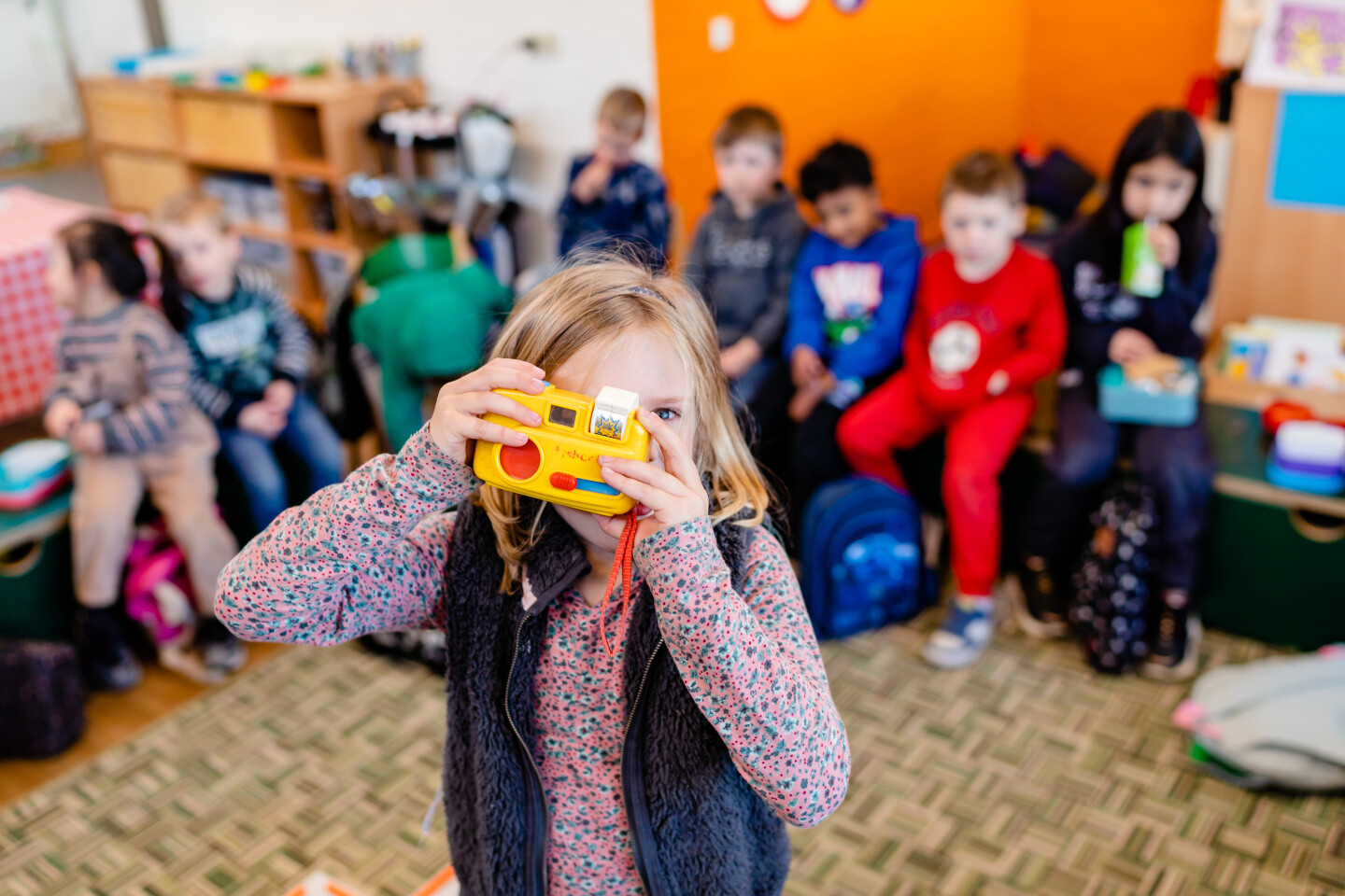 Leerkracht met kinderen handen in de lucht